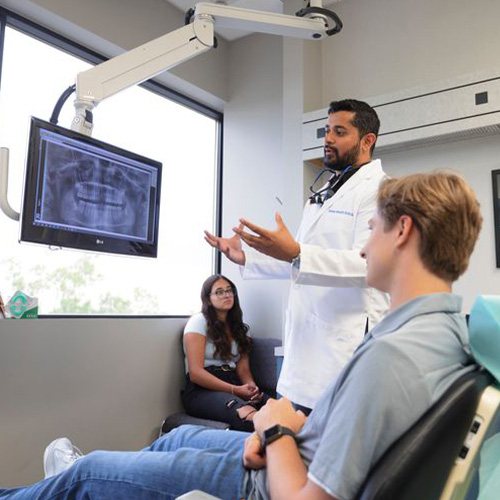 Dentist discussing treatment with patient looking at X-rays