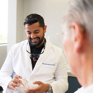 Dentist holding model jaw with clear covering