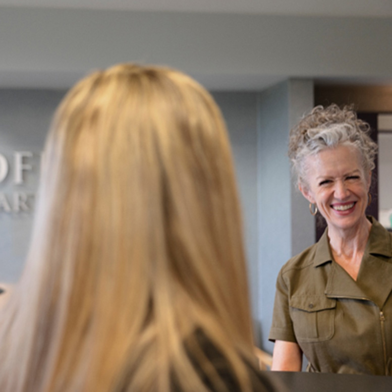 a front desk staff speaking with a patient