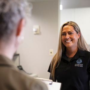 Patient approaching front desk personnel with her dental insurance form