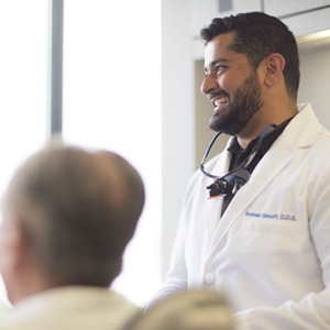 Dr. Shroff smiling while consulting with patient about affordability options at Shroff Dental Arts