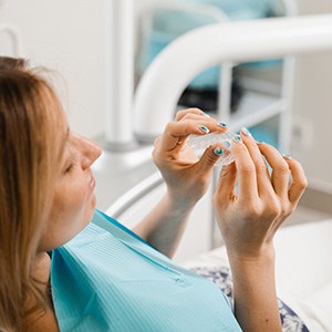 Patient holding clear aligner in treatment chair
