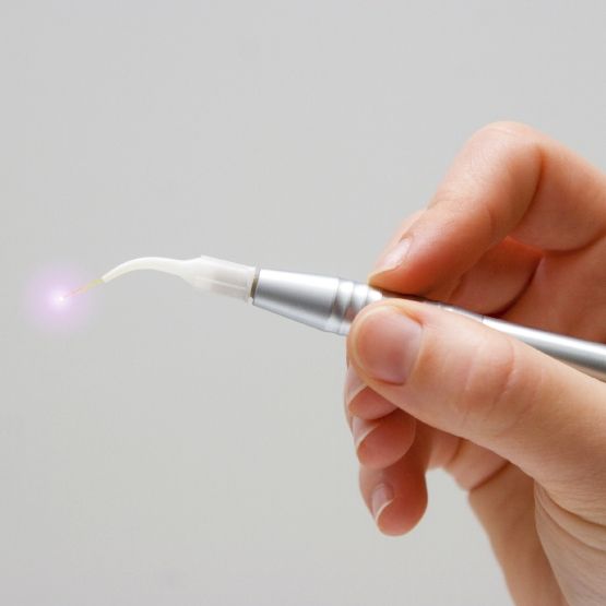 Fingers holding a soft tissue laser