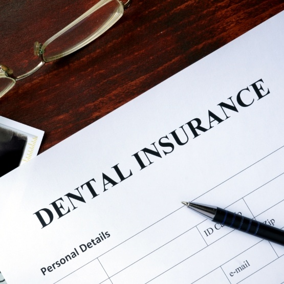 Dental insurance form on table with pen and glasses