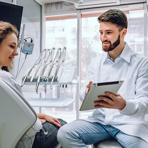 Dentist reviewing information with patient on clipboard