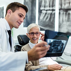 Dentist showing smiling patient X-ray