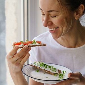 Smiling woman while eating healthy snack