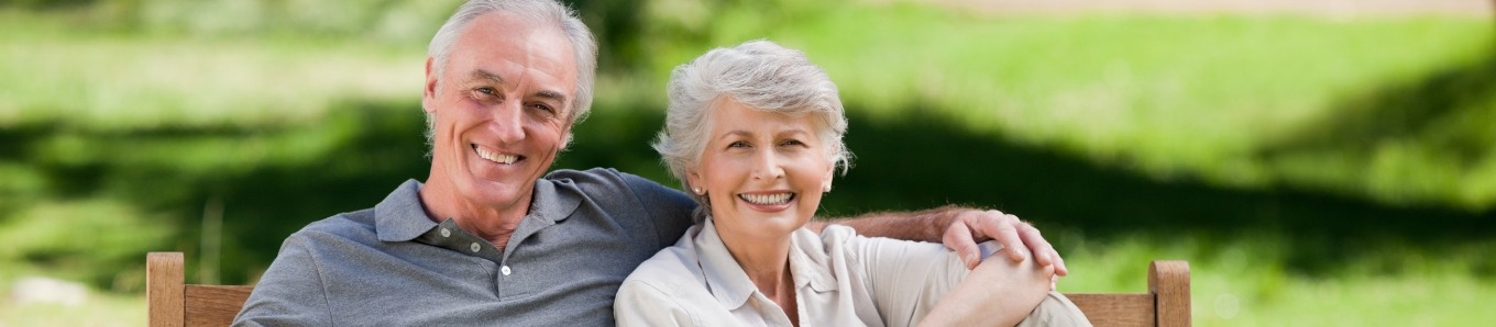 Senior couple sitting on bench and smiling