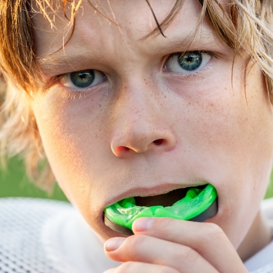 Boy in football uniform with green mouthguard