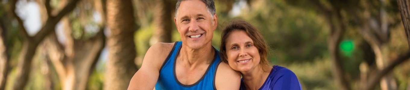 Senior couple smiling outside in jogging outfits