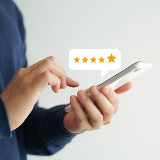 Person using phone to leave five star review